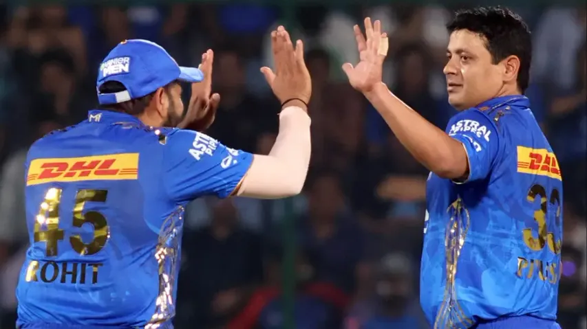 MI bowler Piyush Chawla with team captain Rohit Sharma celebrate the dismissal of DC's Lalit Yadav 