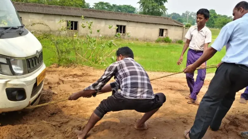 Students pull school van stuck on damaged road in Odisha’s Keonjhar; locals blame sand mafia