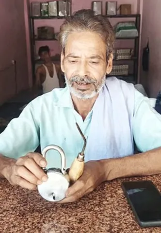 पुवायां में दुकान का टूटा ताला और मौके पर मिला सूजा  दिखाते प्रेमबाबू।