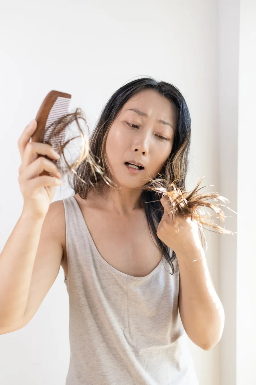 young-brunette-girl-holds-a-comb-with-hair-falling-2023-11-27-05-21-56-utc (1)
