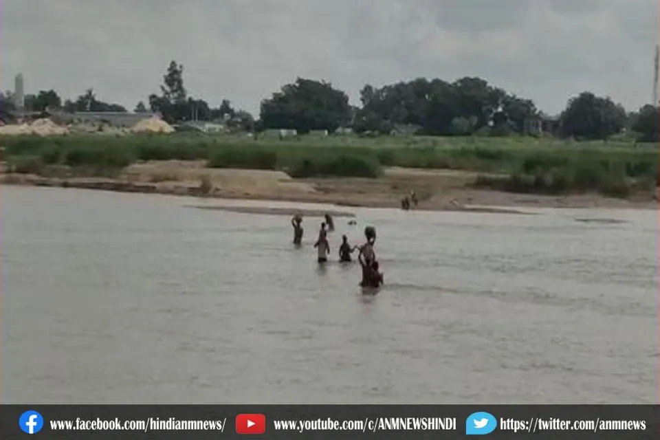 हाथ में जान की बाजी लगाकर नदी पार (वीडियो)