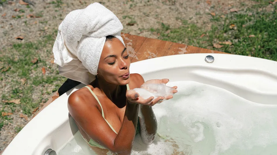 An image of a woman starting her body care routine with a shower using body wash