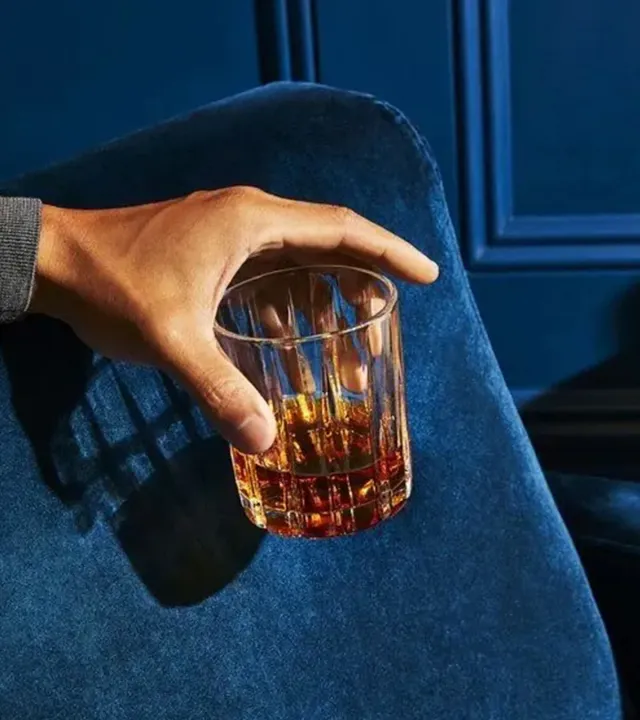 Hand holding a glass of luxury whisky–premium drinking culture in India
