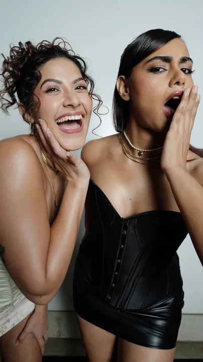 Two women podcast hosts-one in black and the other in white pose for the camera, representing best podcasts India, and the evolution the medium that has led to many must listen Indian podcasts