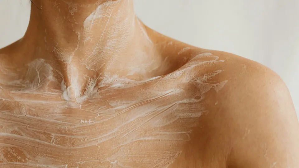 Foaming cleanser on a woman's décolletage with potential endocrine disrupting chemicals in beauty products