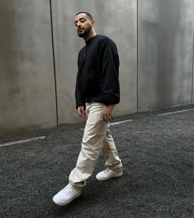 A man with white sneakers thinking how to clean white shoes