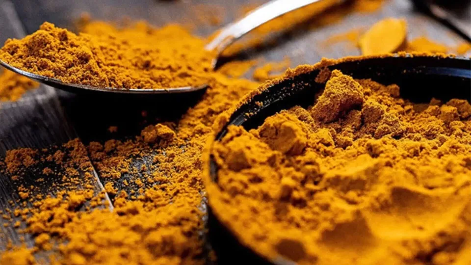 A bowl of Kasturi Manjal on a wooden table