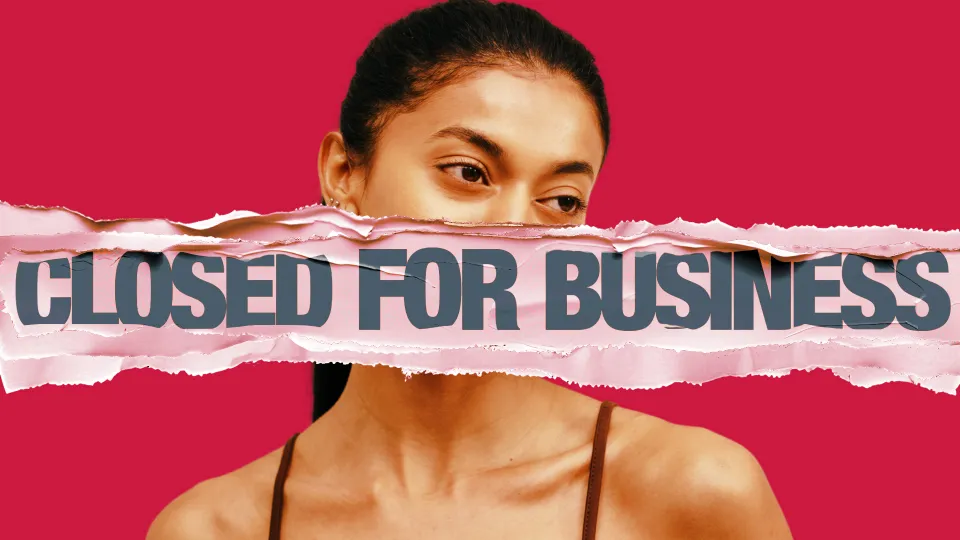 A picture of a woman against a red backdrop with 'closed for business' smeared all the over her face