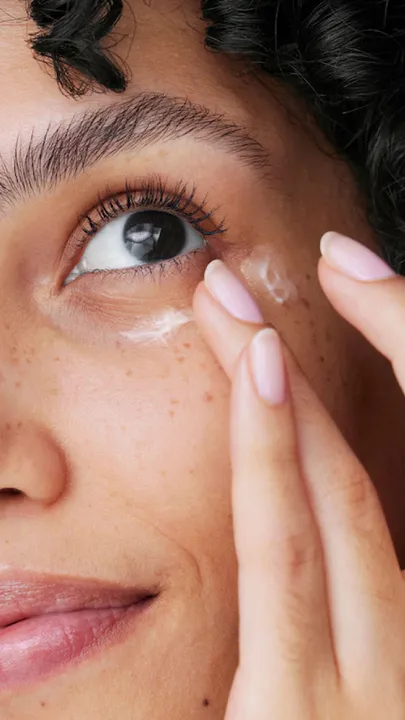 A female applying the best under eye cream with her ring finger