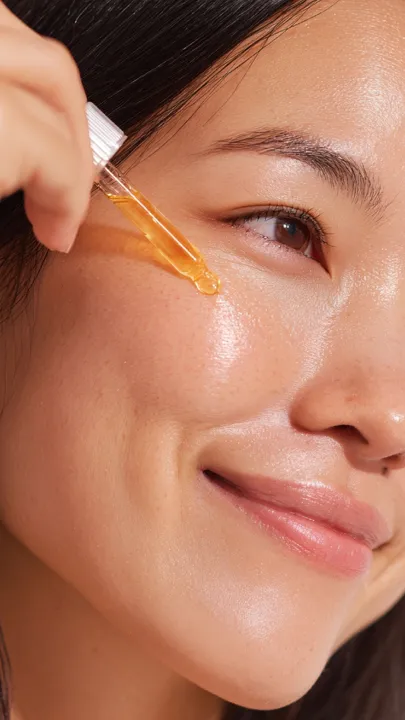 A woman applying serum on the cheeks