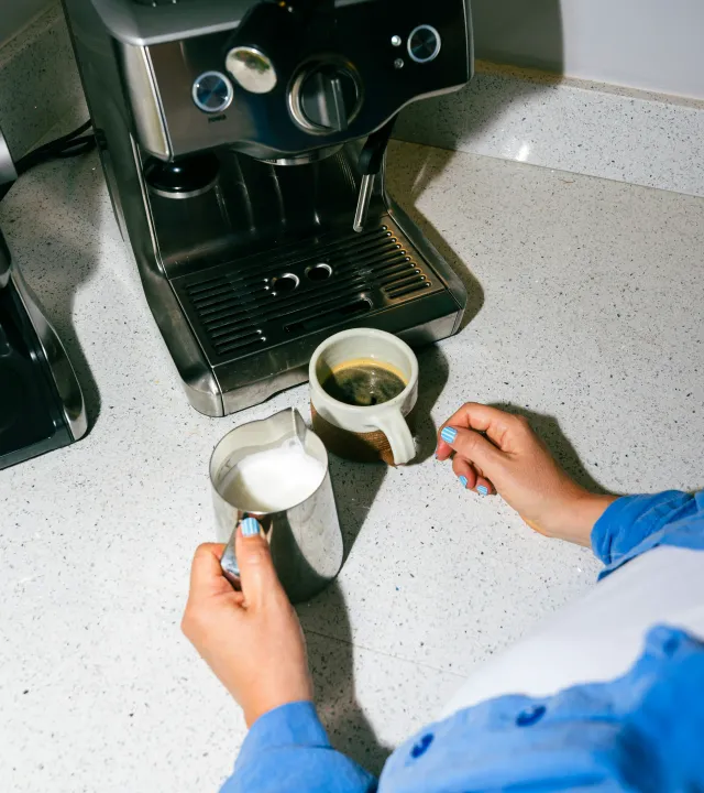 A picture of a person making coffee using a machine and one of the best indian coffee roasters to show how Indian coffee brands are getting popular with the rise of home brewing coffee India