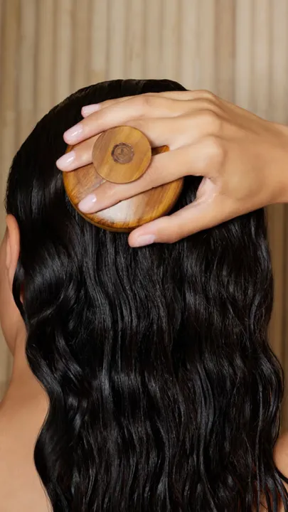 A woman massaging her scalp after using the best hair oil