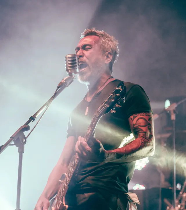 A picture of the an older person singing into the mic to show how indian music bands are making a comeback in 2026