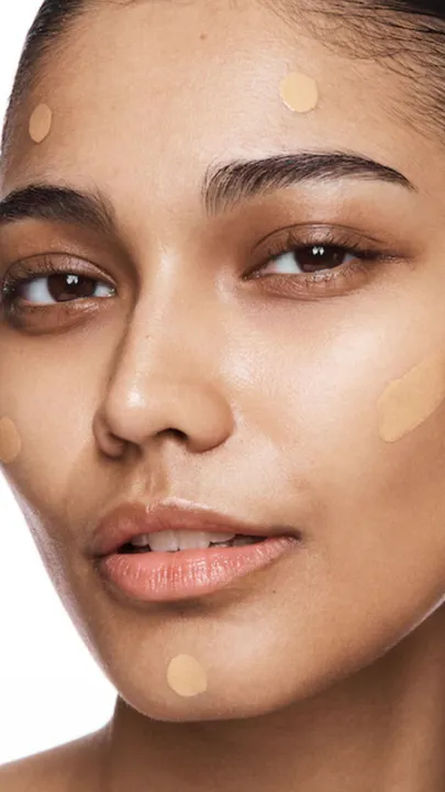 A woman with a few smears of foundation with SPF on her face