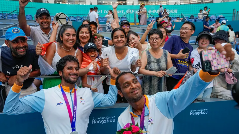 India's silver medalist tennis players Saketh Myneni and Ramkumar Ramanathan take a selfie with fans after the presentation ceremony of men's doubles tennis event at the 19th Asian Games