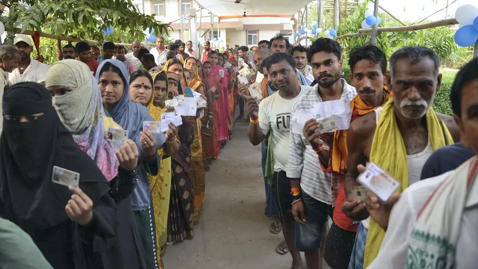 Voters show their ID cards as they wait to cast their votes for the fifth phase of Lok Sabha elections, in Hajipur, Monday, May 20, 2024.