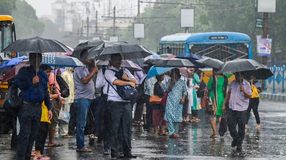 Commuters wait to board a bus at a stop during rain in the aftermath of Cyclone Remal's landfall, in Kolkata, Monday, May 27, 2024