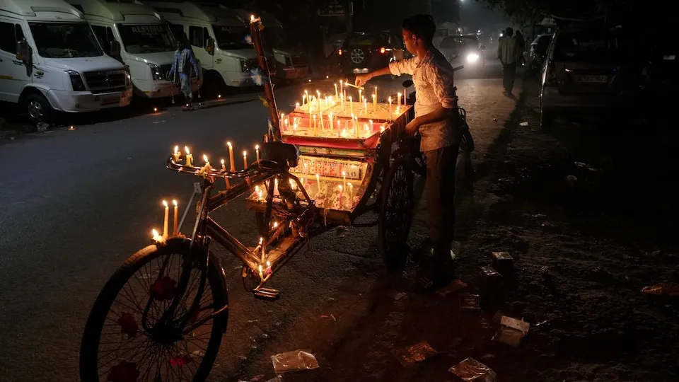 A rickshaw puller lights candles on his rickshaw during the Diwali festival, at Rani Garden, Shastri Nagar, in East Delhi, Thursday, Oct. 31, 2024.