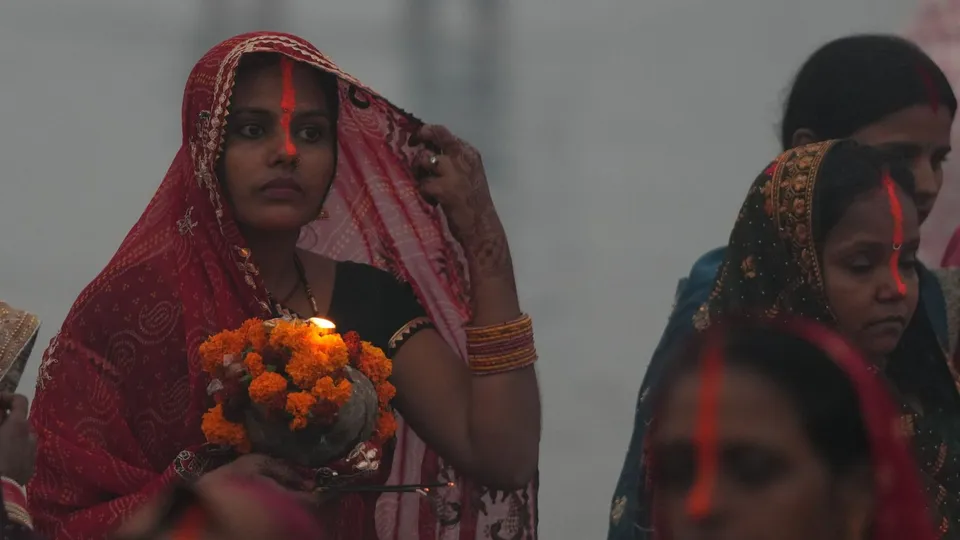 A devotee at the bank of River Yamuna during the last day of Chhath Puja festival, in Noida, Friday, Nov. 8, 2024.