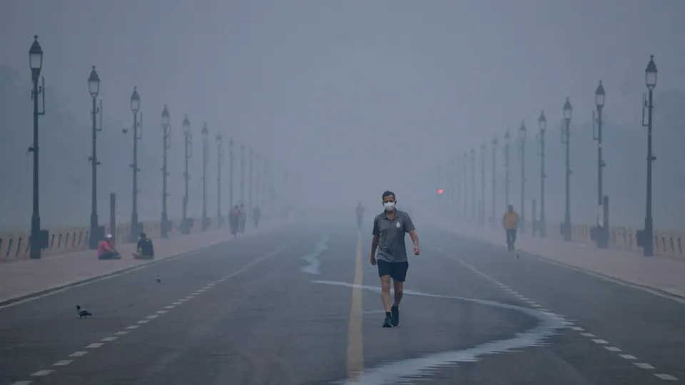 A pedestrian at Kartavya Path amid smog, in New Delhi