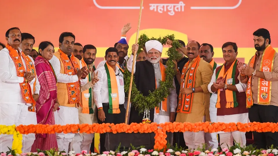 Prime Minister Narendra Modi being felicitated during a public meeting ahead of Maharashtra Assembly elections, in Solapur, Maharashtra, Tuesday, Nov. 12, 2024.