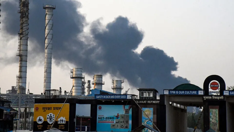 Workers wait outside after an explosion at a refinery of Indian Oil Corporation, in Vadodara, Monday, Nov. 11, 2024.