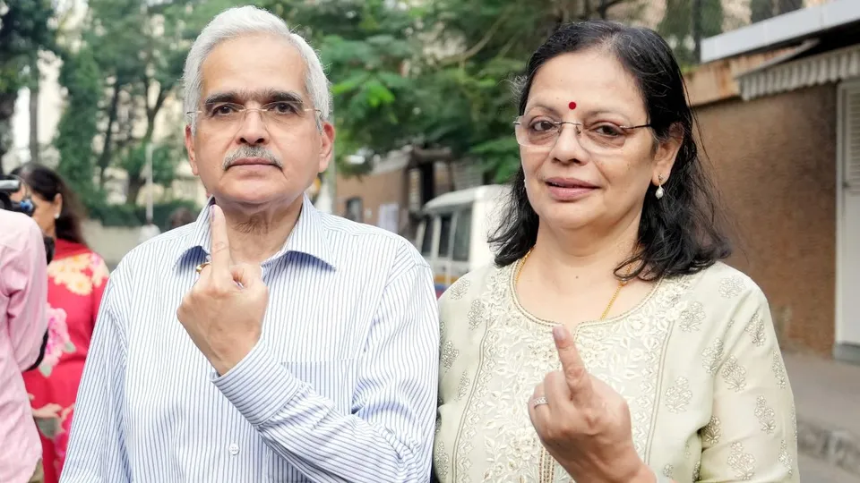 RBI Governor Shaktikanta Das and his wife show their fingers marked with indelible ink after casting votes at a polling station during the Maharashtra Assembly elections, in Mumbai, Wednesday, Nov. 20, 2024.