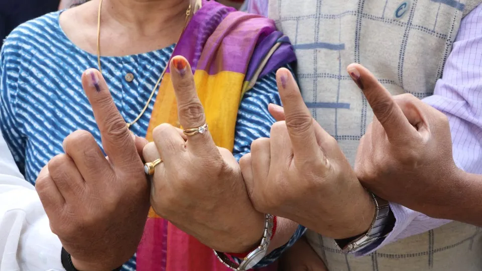 Voters shows their finger marked with ink