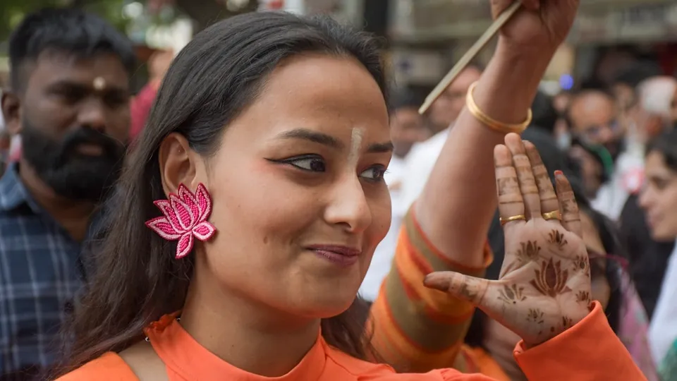 A BJP woman worker wears 'lotus' in her year while celebrating NDA's win in Maharashtra Assembly elections, in Nagpur, Saturday, Nov. 23, 2024.