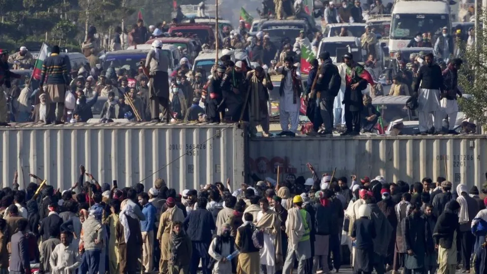 Supporters of imprisoned former premier Imran Khan's Pakistan Tehreek-e-Insaf party, remove shipping container to clear way for their rally demanding Khan's release, in Islamabad, Pakistan