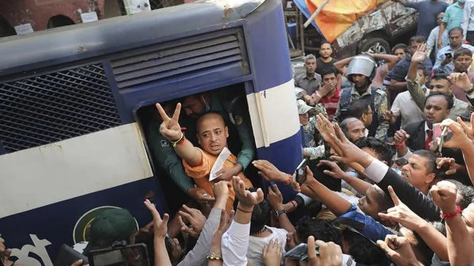 Hindu monk Chinmoy Krishna Das Prabhu shows a victory sign as he is taken in a police van in Chittagong/Chattogram, Bangladesh