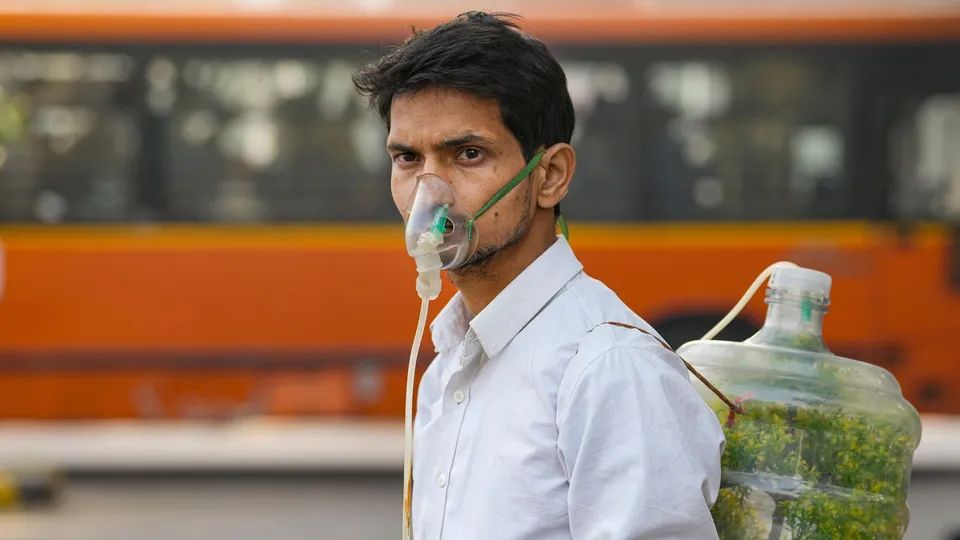 A protester wears an oxygen mask during a protest against air pollution, near the Parliament House complex, in New Delhi