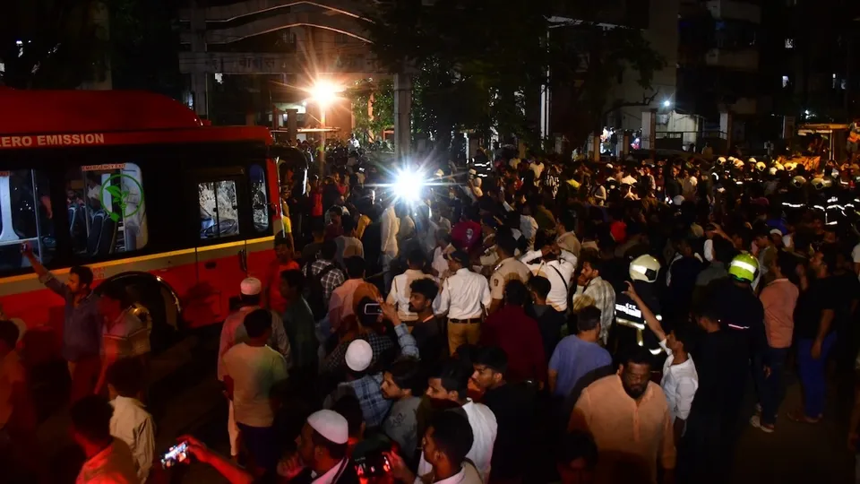 Security personnel and other people gather near the wreckage of vehicles after a Brihanmumbai Electric Supply and Transport (BEST) undertaking's bus rammed into pedestrians as well as vehicles on a road at Kurla, in Mumbai, Monday, Dec. 9, 2024.