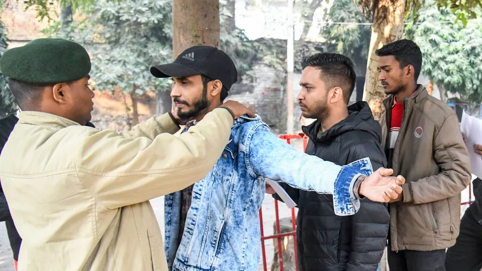 Applicants undergo security checks outside an exam center before appearing for the Bihar Public Service Commission's 70th Combined (Preliminary) Examination, in Patna, Friday, Dec. 13, 2024.