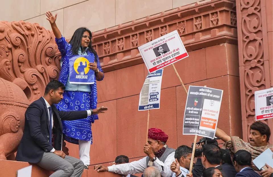 Congress MP Jebi Mather climbs the wall of Makar Dwar as NDA members hold placards during protests at Parliament complex on Thursday, Dec. 19, 2024.