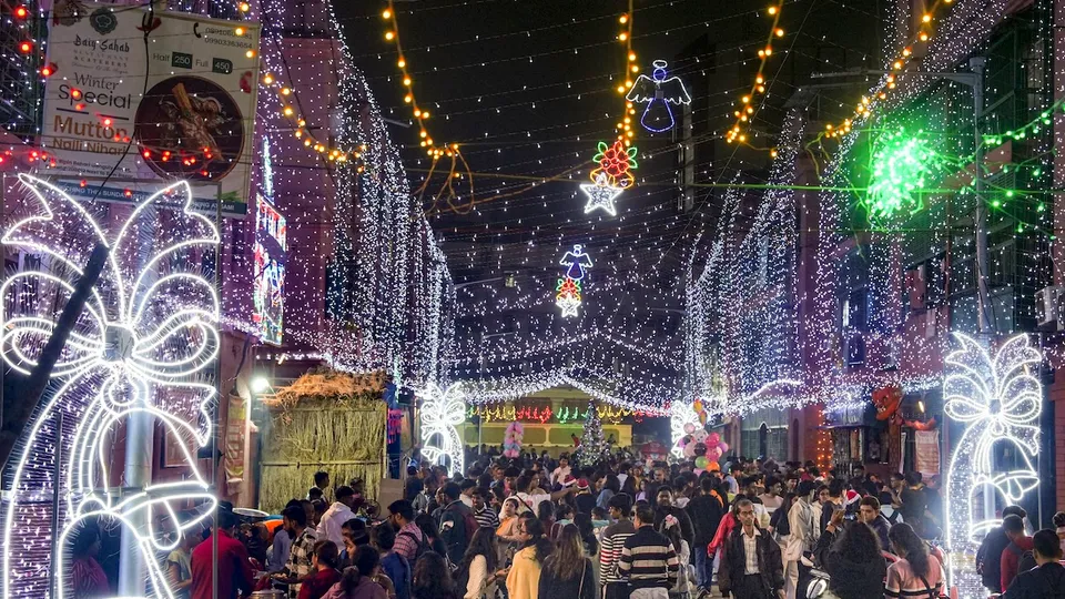 People at Anglo Indian community's residential area Bow Barracks which is decorated with lights on Christmas eve, in Kolkata, Tuesday, Dec. 24, 2024.