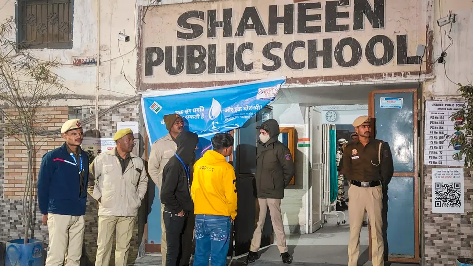 Security personnel stand guard outside a polling booth during the Delhi Assembly elections, at Shaheen Bagh area in New Delhi on Wednesday, Feb. 5, 2025.