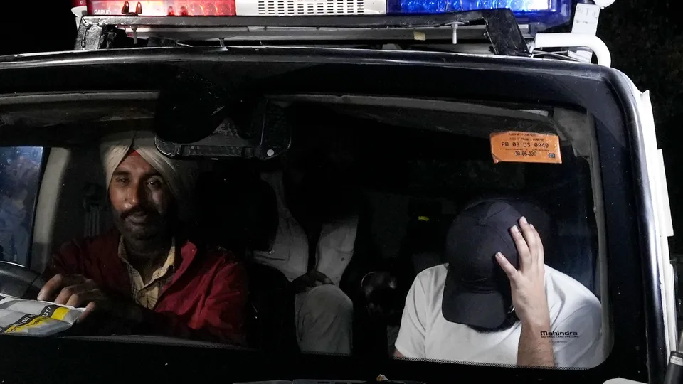 Indians deported from the U.S. being escorted by the police as they leave the airport upon their arrival in Amritsar on early Sunday, Feb. 16 , 2025.