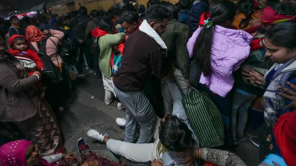 A man falls amid a huge rush of passengers for boarding an overcrowded train for Prayagraj’s Mahakumbh, at the New Delhi Railway Station on Saturday, Feb 15, 2025.