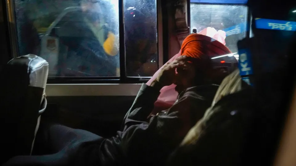 Illegal Indian migrant deported from the U.S. being escorted by the police as they leave the airport upon their arrival, in Amritsar, early Sunday, Feb. 16 , 2025.