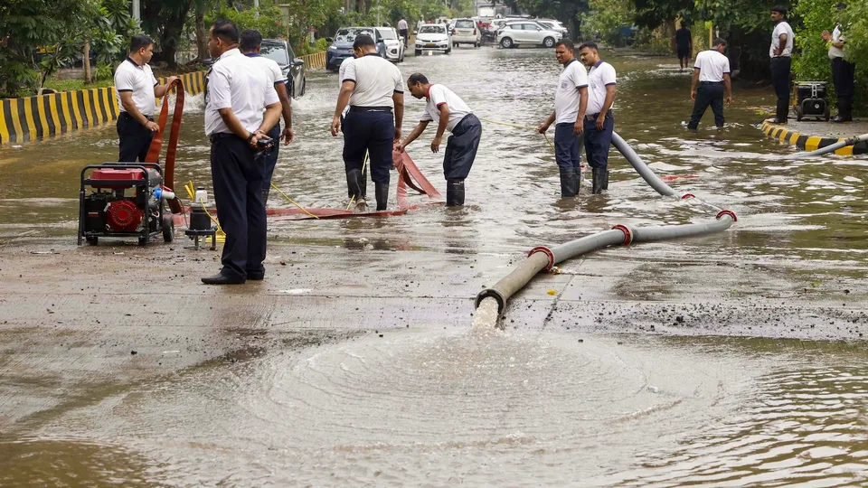 Firemen drain water from a flooded road after heavy monsoon rainfall in Navi Mumbai on Tuesday, May 27, 2025.
