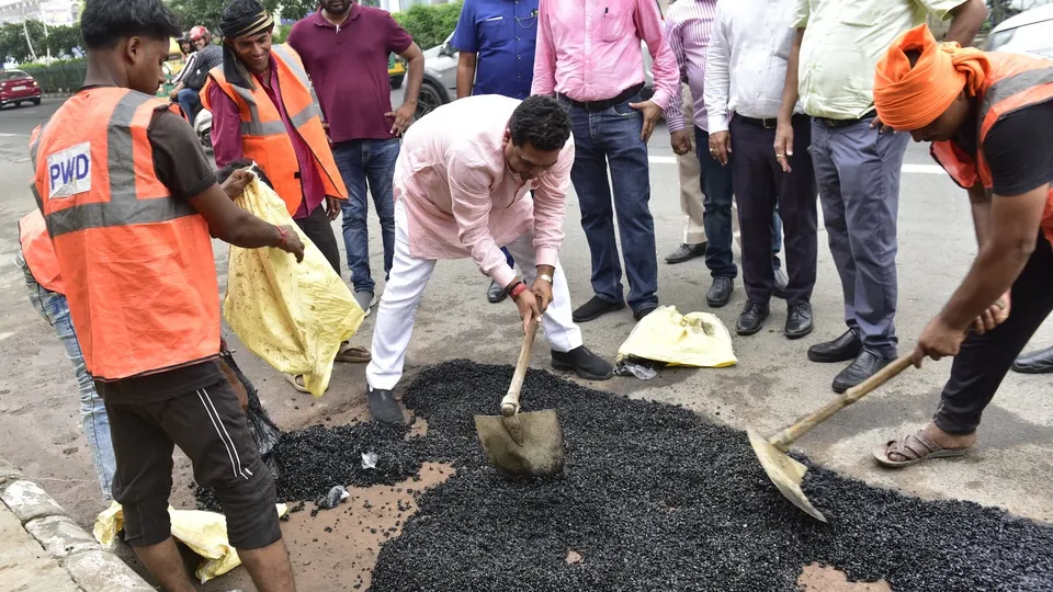 Dehi minister Kapil Mishra participates in a hands-on road repair effort on Vikas Marg, part of a PWD initiative, on Tuesday, June 24, 2025.