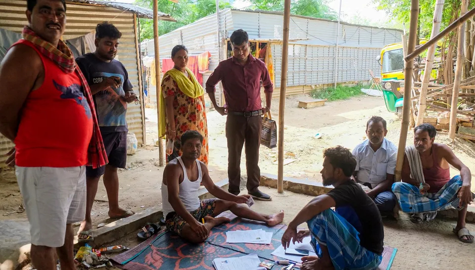 People from West Bengal fill out forms for police verification at a slum area in Gurugram on Friday, July 25, 2025.