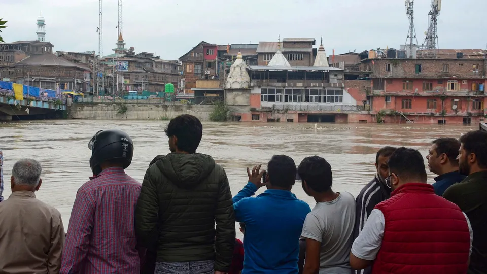 People look at a swollen Jhelum river following heavy rains, in Srinagar, Wednesday, Aug. 27, 2025.
