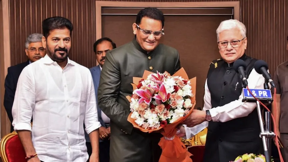 Telangana Governor Jishnu Dev Verma congratulates Congress leader and former cricketer Mohammad Azharuddin after the latter took oath as a state minister during a swearing-in ceremony, at Raj Bhavan, in Hyderabad on October 31, 2025. Chief Minister A Revanth Reddy is also seen.