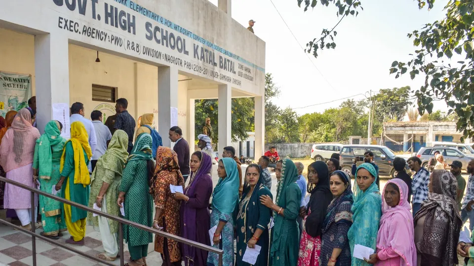 Voters wait in a queue to cast their votes at a polling station during the Nagrota assembly constituency bypoll, in Jammu district, Tuesday, Nov. 11, 2025.