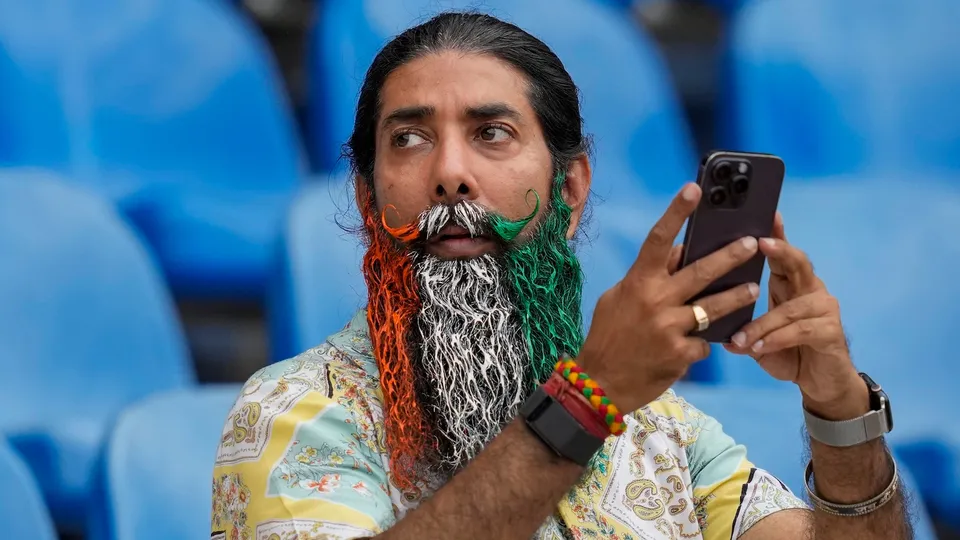A team India fan with his beard coloured in the country's national flag takes photographs during a practice session ahead of an ICC Men's T20 World Cup 2026 cricket match between India and Pakistan, at R Premadasa Stadium, in Colombo, Sri Lanka, Saturday, Feb. 14, 2026.