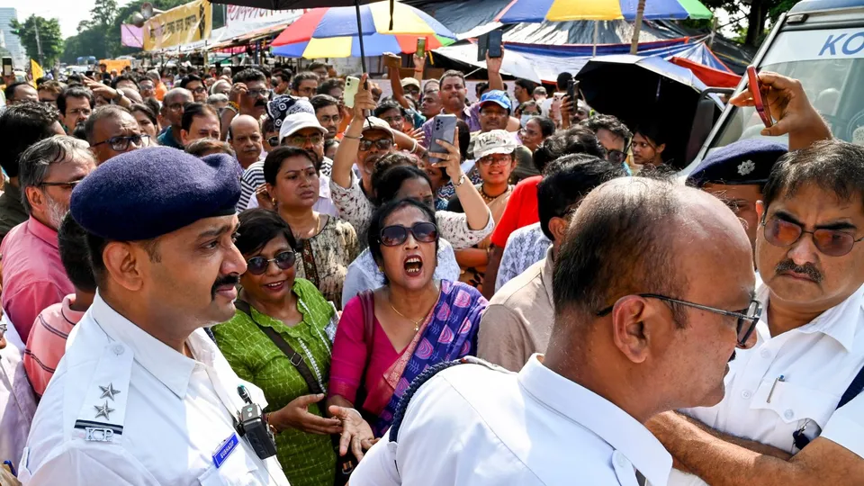 Security personnel stand guard as people protest near junior doctors' hunger strike 'manch' against the alleged rape and murder of a trainee doctor, in Kolkata, Friday, Oct. 11, 2024.