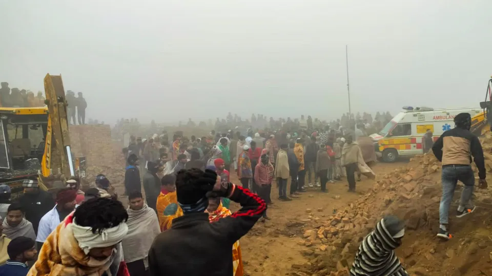 People gather around a site where a wall collapse killed at least six people and injured several, in Haridwar district