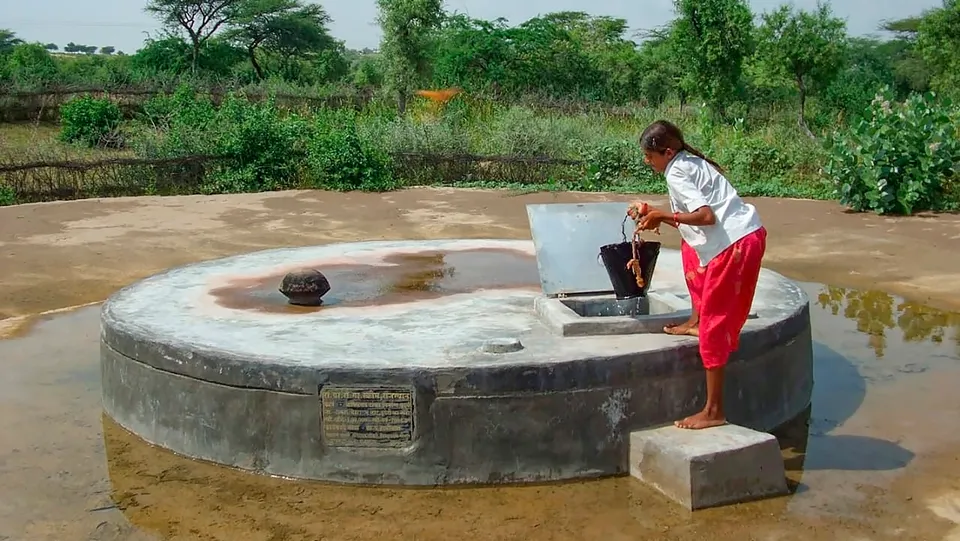 A young woman fills a bucket of water from a 'tanka', in Barmer district, Rajasthan